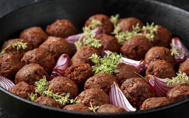 Albóndigas vegetarianas veganas con tomillo y cebolla en sartén de hierro fundido - Foto, Imagen