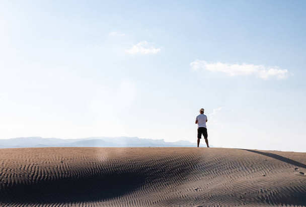 Muž, který volá s chytrým telefonem, stojí sám v pouštních dunách. Kopírovat prostor - Fotografie, Obrázek