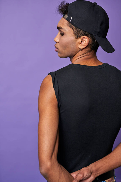 Portrait of young brunette man back view. Handsome male in black t-shirt, cap. Transgender model - Photo, Image