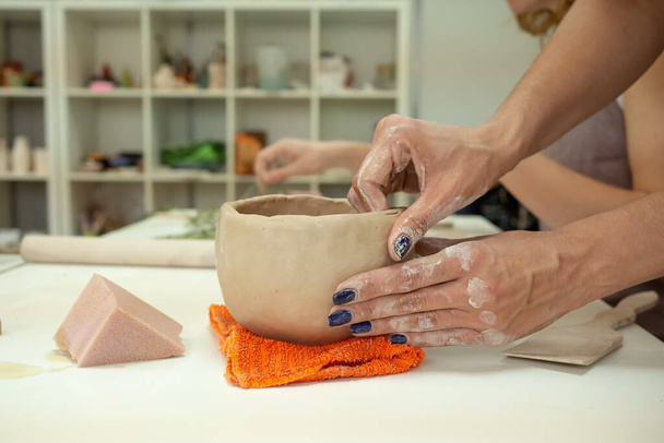 Woman hand potter making clay cup in pottery workshop studio. Process of creating ceramic mug. Handmade, hobby art and handicraft concept. - Fotó, kép