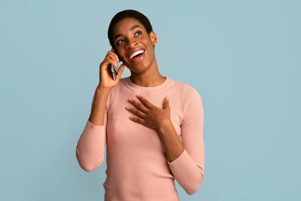 Telefon komórkowy. Portret szczęśliwej Afroamerykanki mówiącej przez komórkę - Zdjęcie, obraz