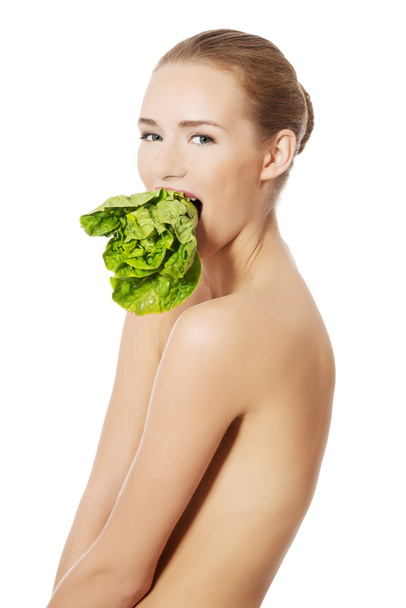 Woman with lettuce in mouth - Fotó, kép