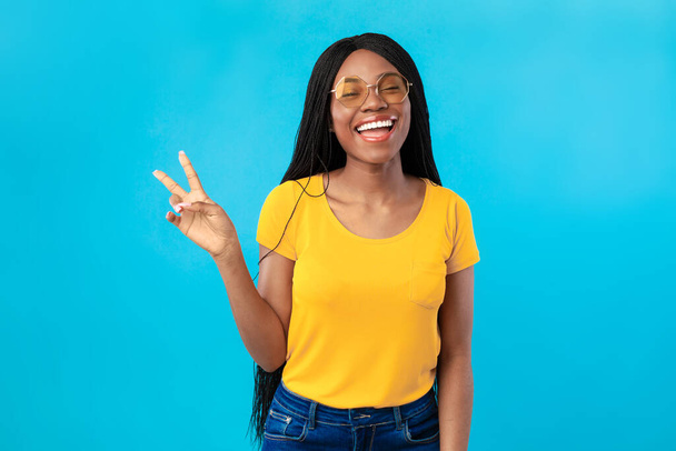Successful African American Lady Gesturing Victory Symbol On Blue Background - Photo, Image