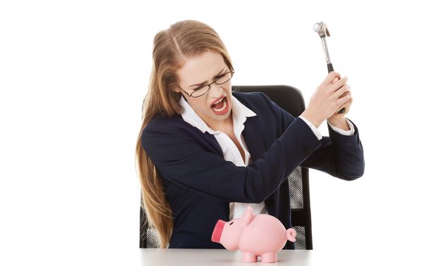Business woman is trying to destroy piggy bank - Zdjęcie, obraz