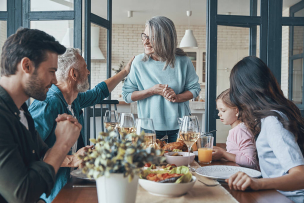 現代の多世代の家族が一緒に食事をしながらコミュニケーションと笑顔 - 写真・画像