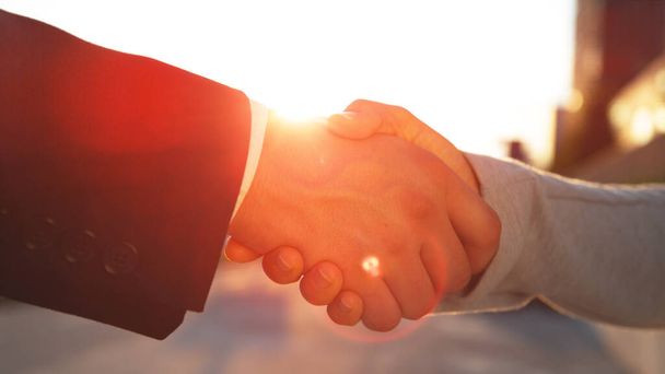 LENS FLARE: Uomo d'affari e donna si stringono la mano dopo un colloquio di lavoro di successo. - Foto, immagini