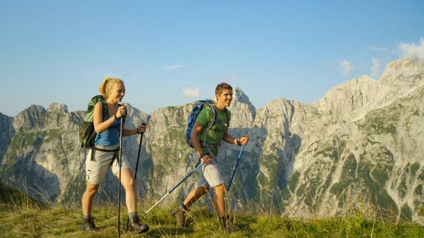 Sporty tourist couple trekking in the stunning Alps on a sunny summer day. - Fotoğraf, Görsel