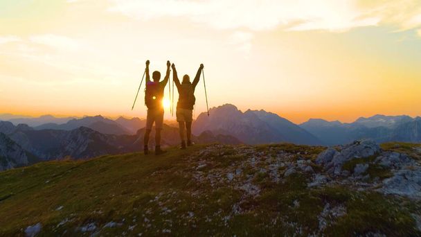 DRONE: Stunning golden sunrise shines on the mountains and excited man and woman - Photo, Image