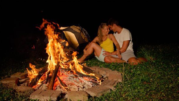 CLOSE UP: Joyful couple touching foreheads while snuggling by the firepit. - Photo, Image