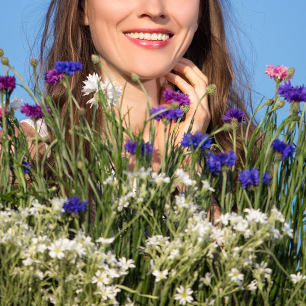Beautiful young woman among flowers - Фото, зображення