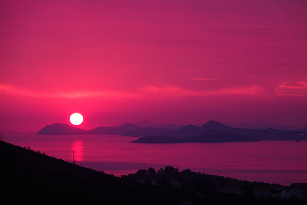 AERIAL: Colourful shot of a sundown producing vibrant colours in Dalmatia. - Foto, Bild
