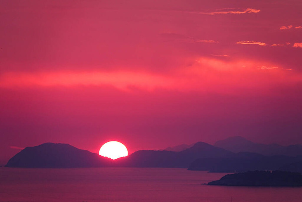 AERIAL: Colourful picture of a sundown producing vibrant colours in Croatia. - 写真・画像