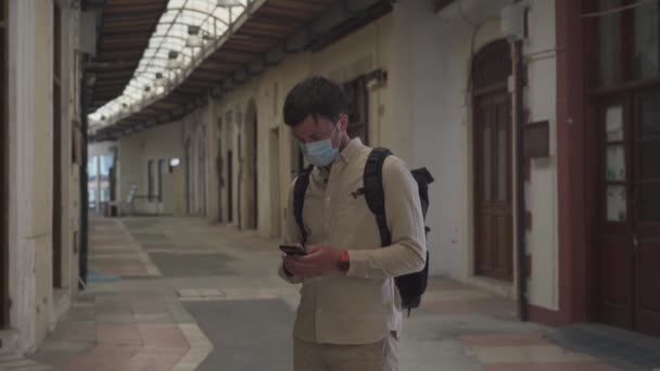 Hombre enmascarado camina en el mercado cerrado durante la pandemia de coronavirus, el bloqueo de Chipre. Hombre con máscara camina por el mercado en el centro de la ciudad. Sin turistas, quiebra de pequeñas empresas bajo COVID 19 - Metraje, vídeo