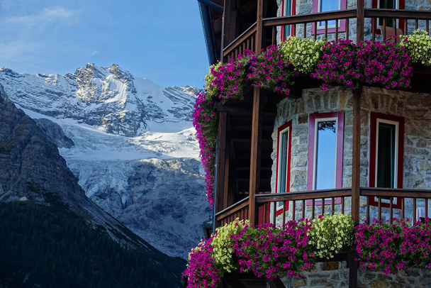 Beautiful shot of colorful flowers covering balcony of a hotel in the mountains - Foto, Bild