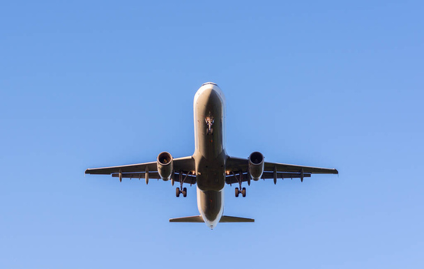 A low angle shot of an airplane in blue sky - Foto, Imagen