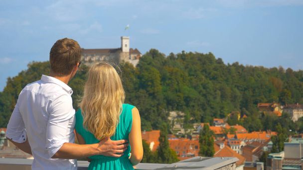 CLOSE UP Young tourist couple observes the city of Ljubljana from scenic rooftop - Фото, зображення
