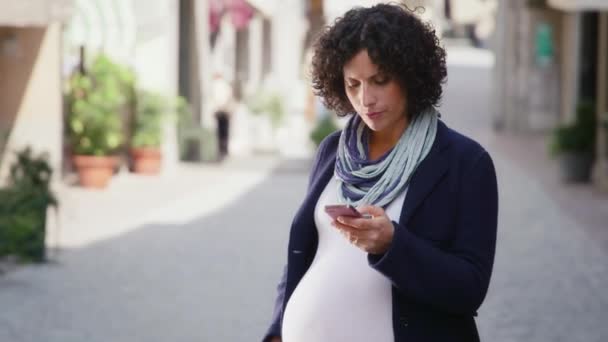 Pregnant woman talking on phone - Záběry, video