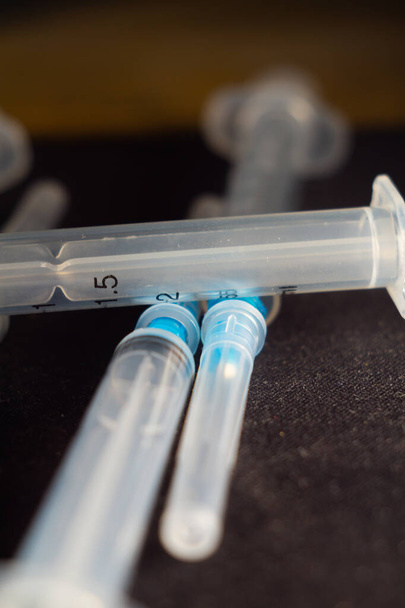 A vertical closeup shot of a pile of medical syringes - Фото, зображення