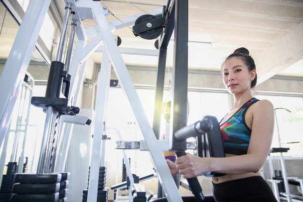 Junge Leute, die in der Turnhalle trainieren. asiatischer Bodybuilder trainiert mit Fitnessbändern im Fitnessstudio. - Foto, Bild