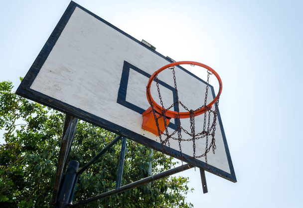 A low angle photo of a basketball basket on a sunny day - Фото, зображення
