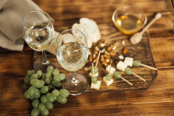 copas de vino con deliciosos aperitivos sobre fondo de madera - Foto, imagen