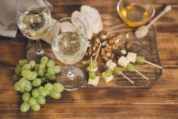 copas de vino con deliciosos aperitivos sobre fondo de madera - Foto, imagen