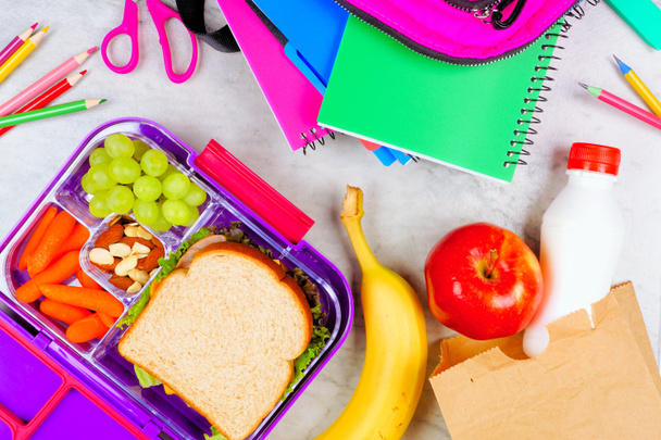 Healthy school lunch with school supplies. Table scene on a white marble background. Back to School concept. - Photo, Image