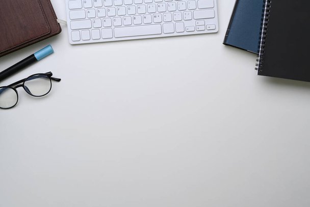 Белый стол с ноутбуком, клавиатурой, очками и копировальным пространством. - Фото, изображение