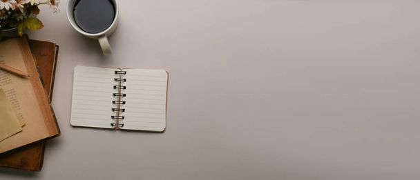Imagen horizontal del lugar de trabajo con taza de café, cuaderno vacío y espacio de copia en el escritorio blanco. - Foto, imagen