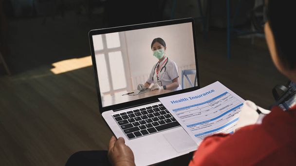 close-up bekijken van volwassen vrouw patiënten met behulp van laptop computer met video gesprek te raadplegen met vrouwelijke arts thuis. - Foto, afbeelding