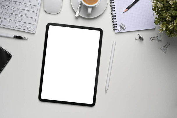 Mock up digitale Tablette mit leerem Bildschirm, Pflanzen-und Bürobedarf auf weißem Bürotisch. - Foto, Bild