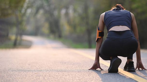 Parkta gün batımında koşuya hazırlanan sportif kadının arka görüntüsü.. - Fotoğraf, Görsel