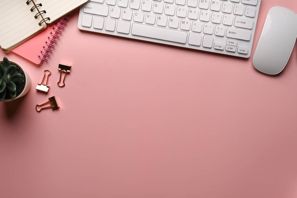 Visão superior espaço de trabalho feminino com teclado sem fio, notebook, xícara de café e espaço de cópia no fundo pastel rosa. - Foto, Imagem