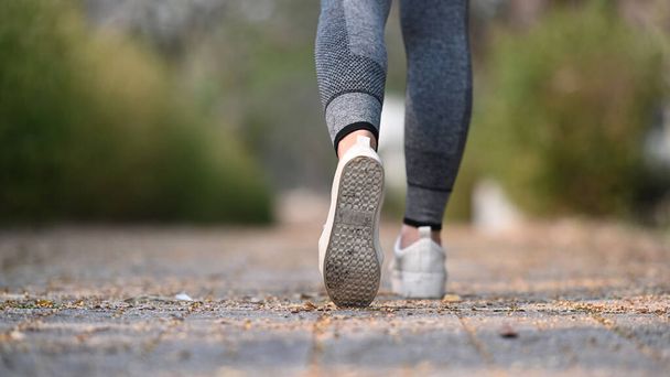 Close up of legs of sportswoman running on the road outside. Healthy Lifestyle. - Φωτογραφία, εικόνα