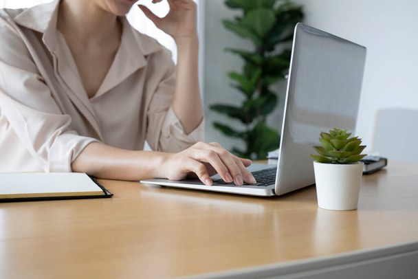 Jonge vrouw accountant concentreren werken op laptop computer op moderne werkplek. - Foto, afbeelding