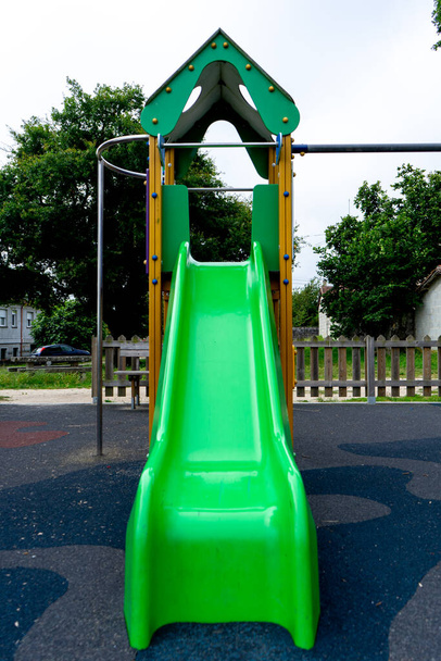 πράσινη διαφάνεια στην παιδική χαρά με μια κατασκευή στην πλευρά της σκάλας που το κάνει να μοιάζει με παλάτι - Φωτογραφία, εικόνα