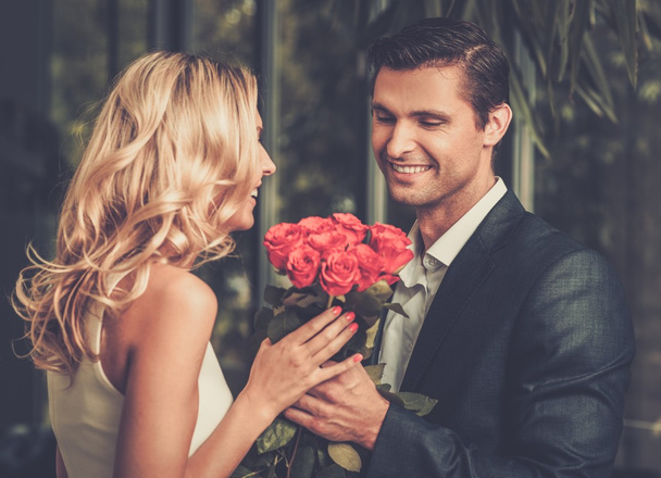 Przystojny mężczyzna z bukiet czerwonych róż randki jego pani - Zdjęcie, obraz