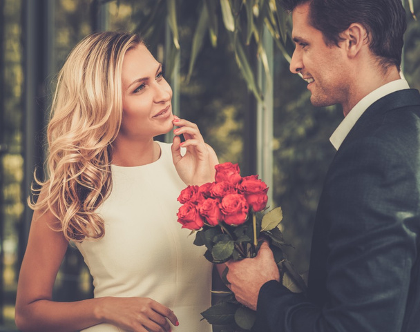 Przystojny mężczyzna z bukiet czerwonych róż randki jego pani - Zdjęcie, obraz
