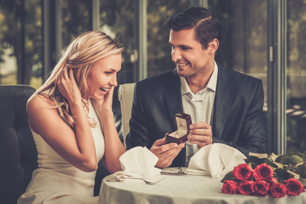 Mann hält Box mit Ring und macht seiner Freundin einen Heiratsantrag - Foto, Bild