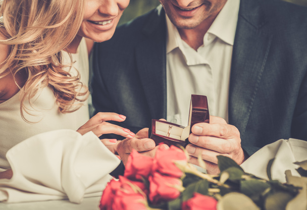 Homem segurando caixa com anel fazendo pedido de casamento para sua namorada
 - Foto, Imagem