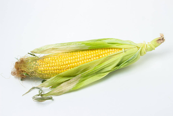 Ucho kukurydzy na białym tle. Świeża kukurydza na kolbie. Zdrowa żywność - Zdjęcie, obraz