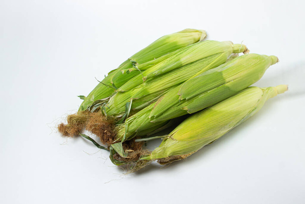 Oreja de maíz sobre fondo blanco. Maíz fresco en la mazorca. Alimento saludable - Foto, Imagen