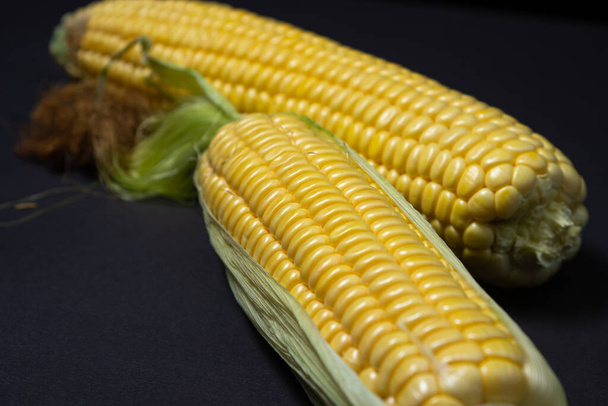 Peeled corn on a black background. Raw fresh corn. Healthy food - Foto, immagini