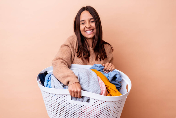 Genç melez bir kadın çamaşırları tutuyor ve gülüyor ve eğleniyor.. - Fotoğraf, Görsel