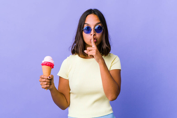Молода змішана жінка їсть морозиво, зберігаючи таємницю або просячи мовчання
. - Фото, зображення