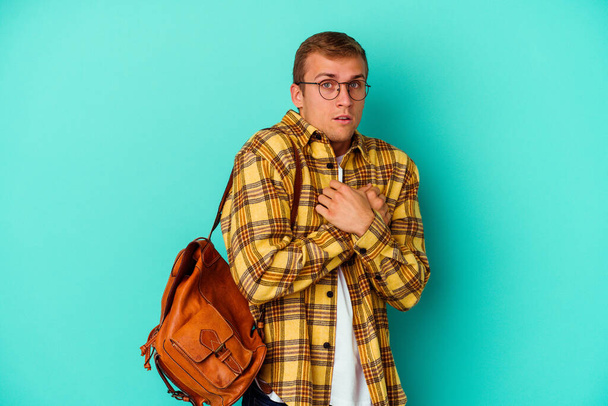 Young caucasian student man isolated on blue background scared and afraid. - Photo, Image