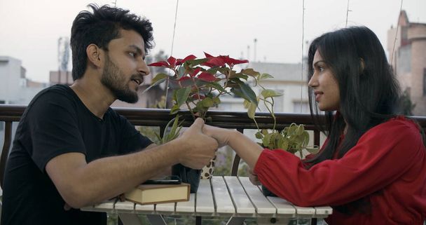 Un jeune couple indien se touchant tout en parlant et en passant du temps dans un café - Photo, image