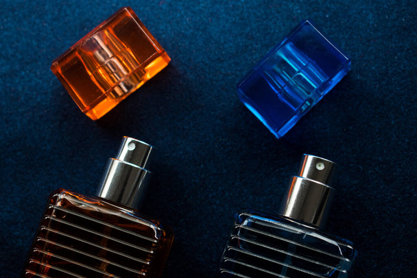 A top view of two perfume bottles on the table with a dark blurry background - Фото, изображение
