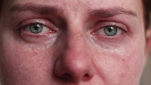 A nő sír. Ideges depressziós lány színes szemekkel és könnyekkel az arcán egyedül otthon. Folynak a könnyek.. - Felvétel, videó
