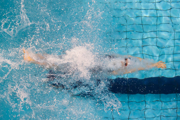 Le nageur, qui saute et plonge dans la piscine sportive intérieure. Concept sportif professionnel. Affiche de sport horizontale, cartes de vœux, en-têtes, site web - Photo, image